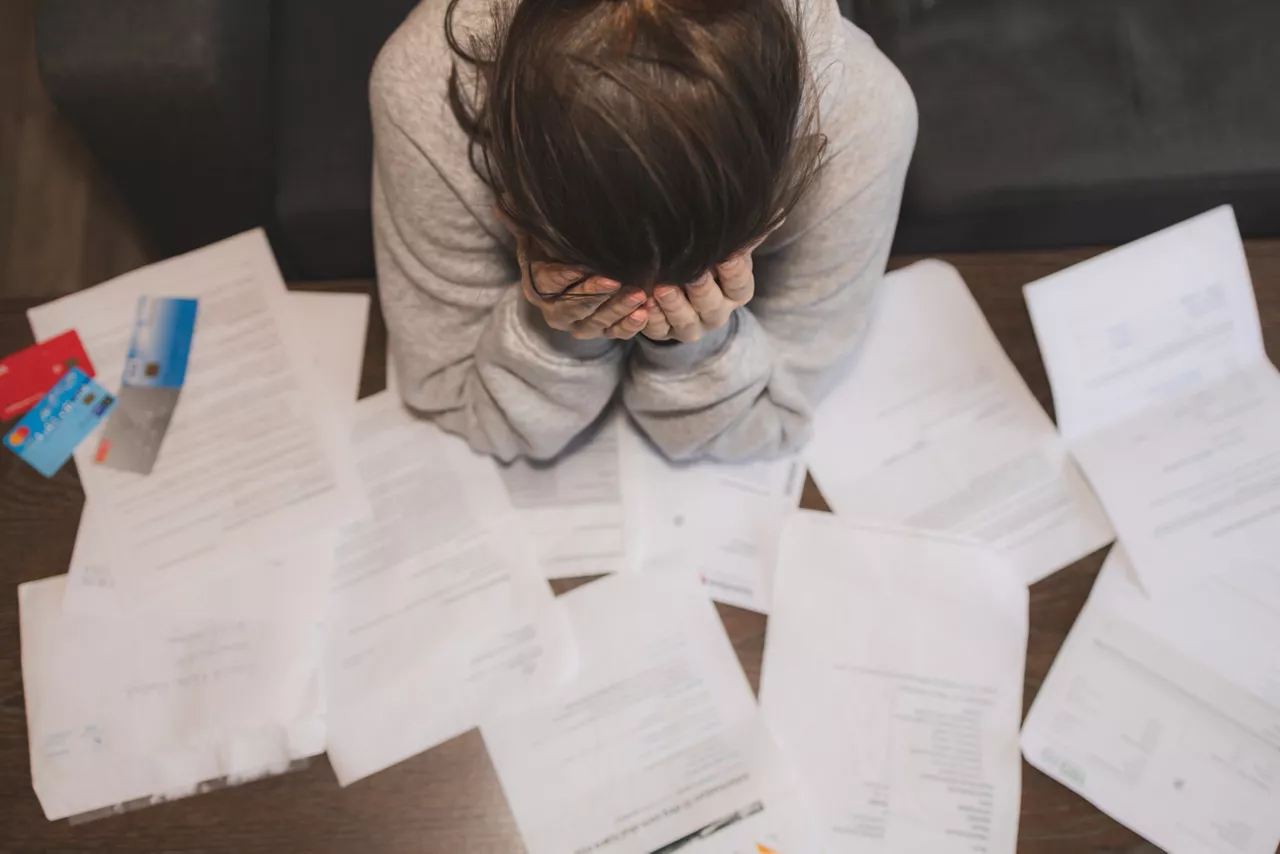 Shocked stressed young woman reading document letter from bank about loan debt financial problem, frustrated worried about bills notification, troubled with bad news or failed test results in mail