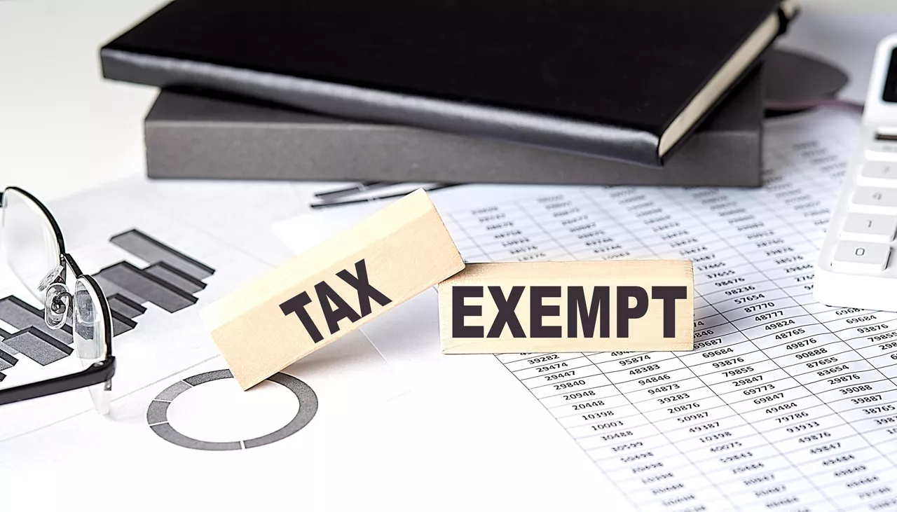 TAX EXEMPT - text on wooden block with chart and notebook