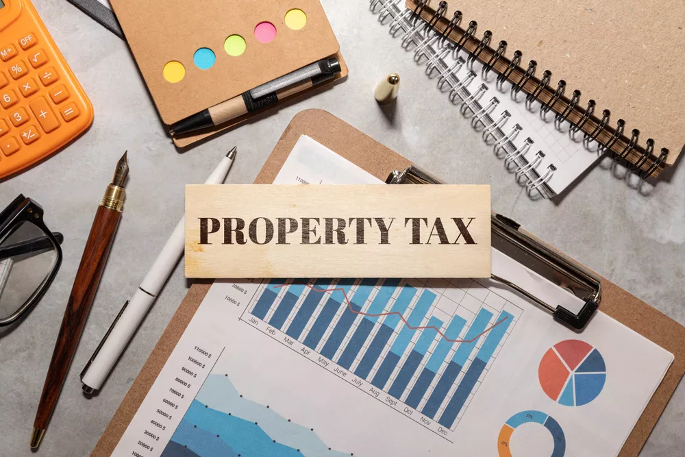 open notepad near a plant in a pot. text Property tax symbol. Concept words Property tax . Business and property tax concept. Copy space.