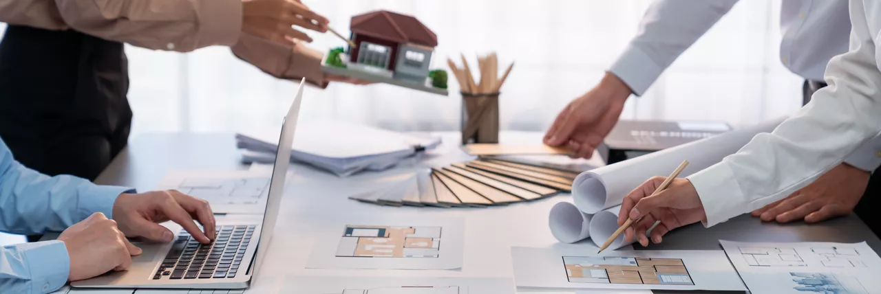 Group of interior designer team in meeting, discussing with engineer on interior design and planning for house project blueprint and model, choosing color sample and mood board materials. Insight