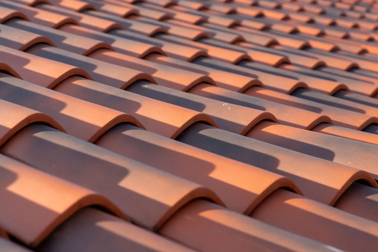 Orange colored classic corrugated roof tiles, shingles, close up texture background with a creative perspective