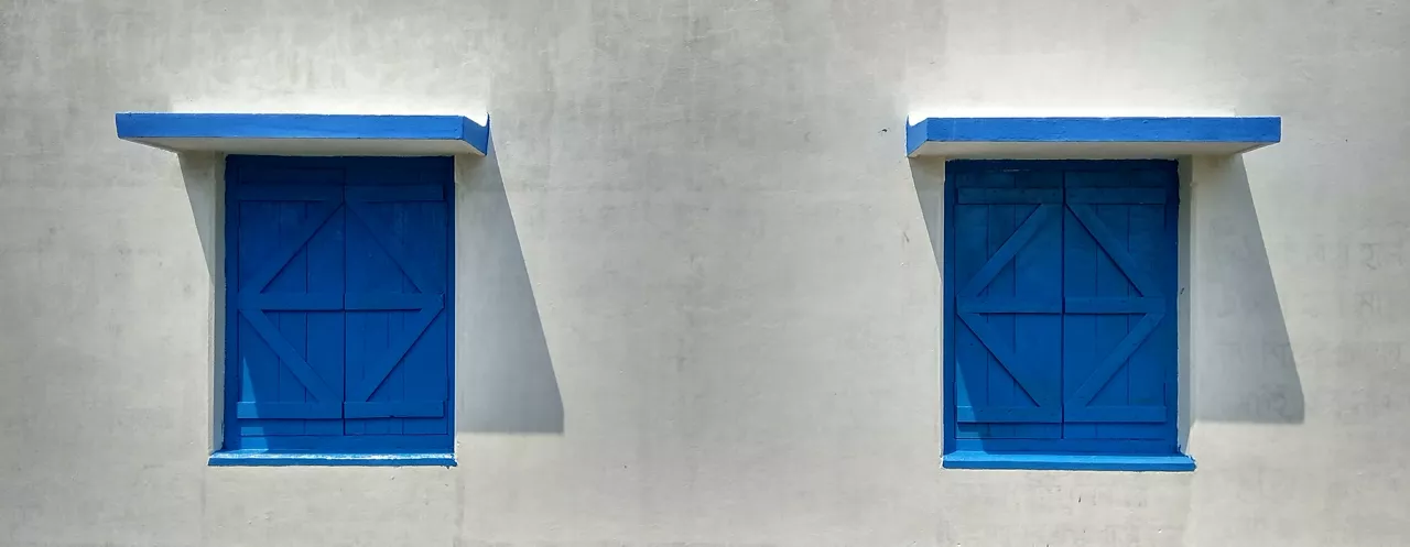 Blue wooden windows with white walls