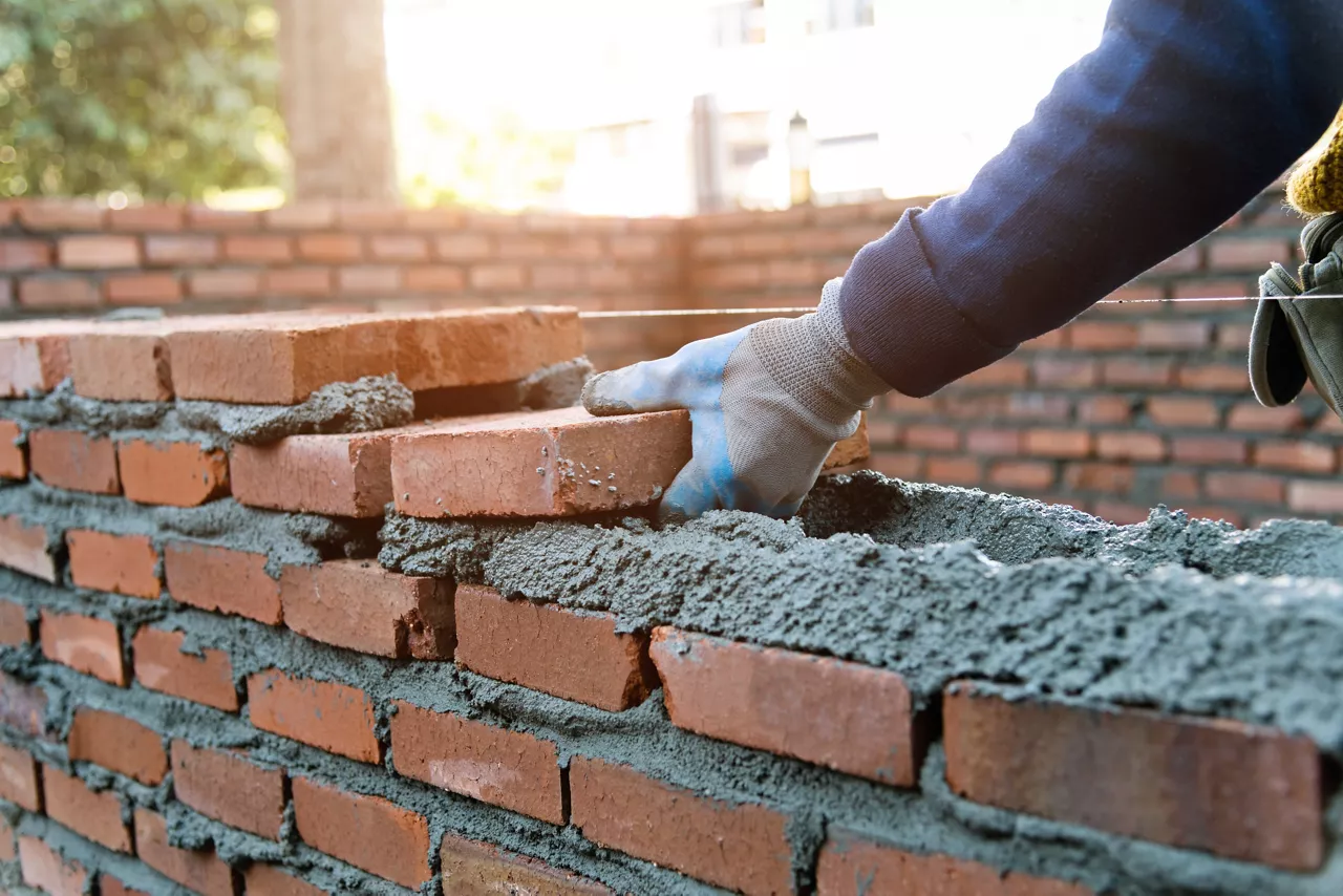 Close up of bricklayer building walls.