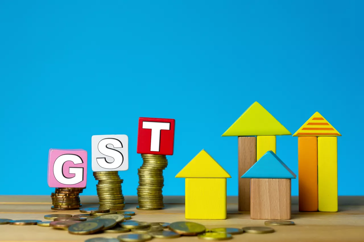 GST for properties. Building from wood cubes stacking with gold coin. Tax, taxation, property and investment concept or other your content.