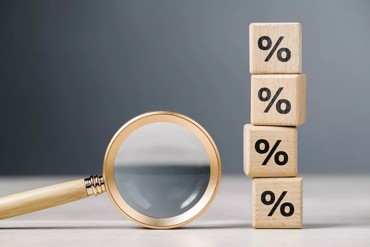 Magnifying glass and stack of wood cubes with percentage icon