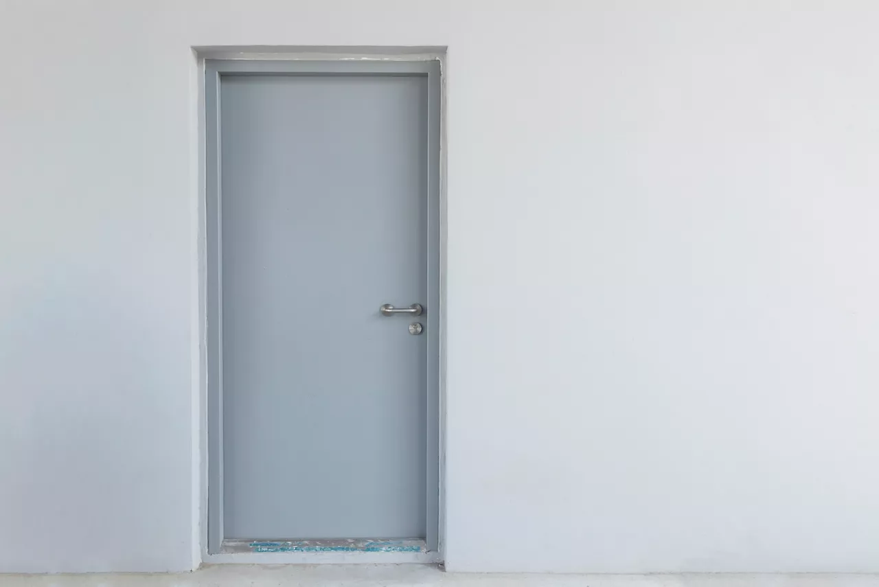 steel door on grey wall background with copy space
