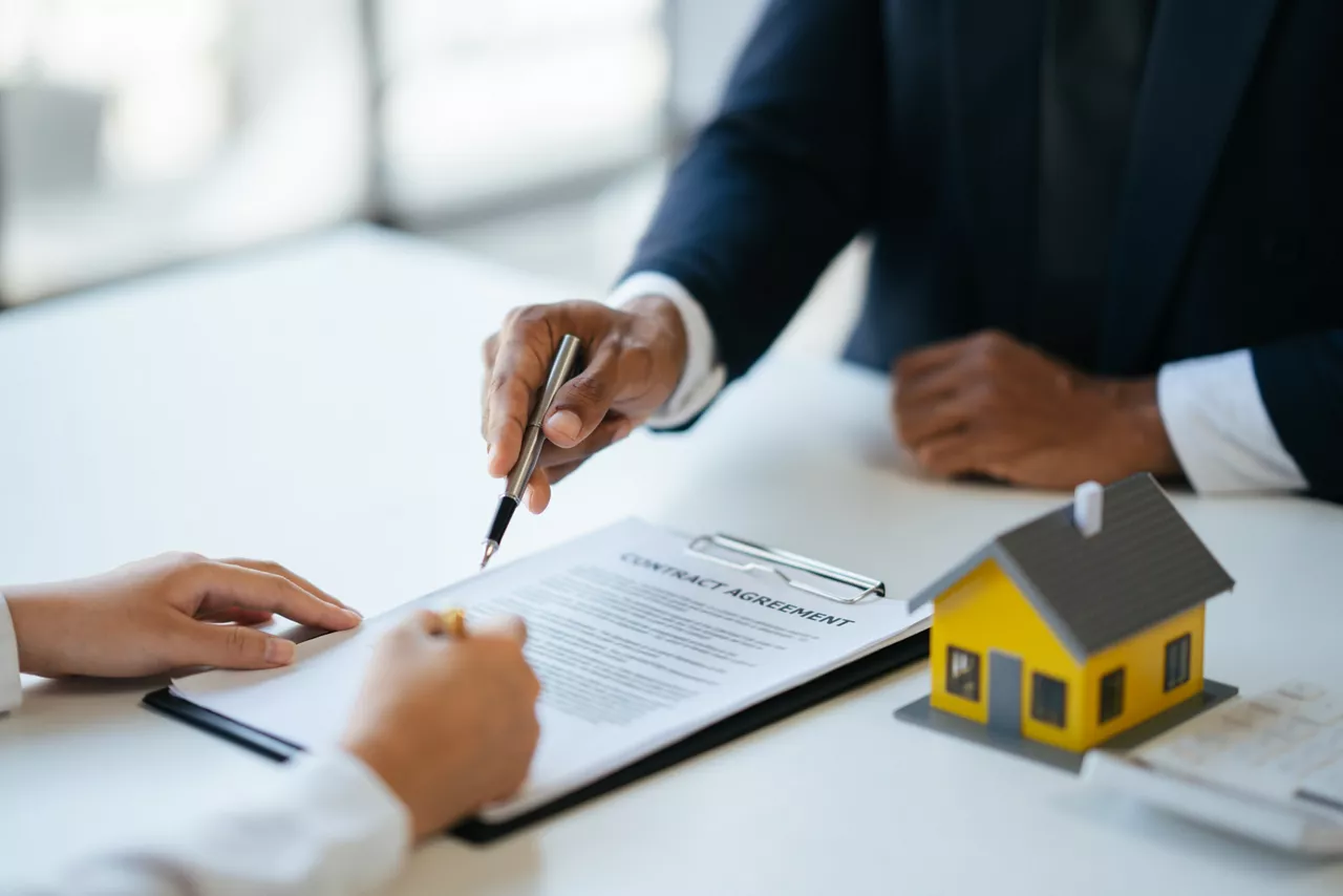 Professional real estate agent guiding and explaining the document process to the customer before the deal was done.
