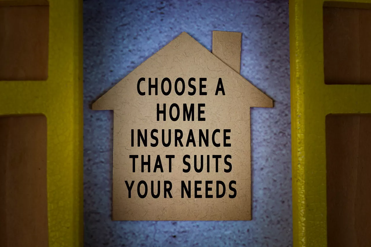 Text on paper house model with window frame background - Choose a home insurance that suits your needs. Home insurance concept.