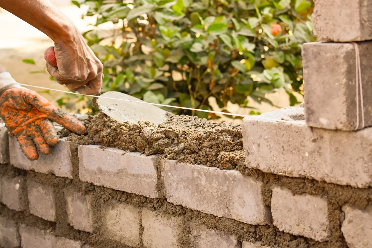 man building concrete bricks wall 