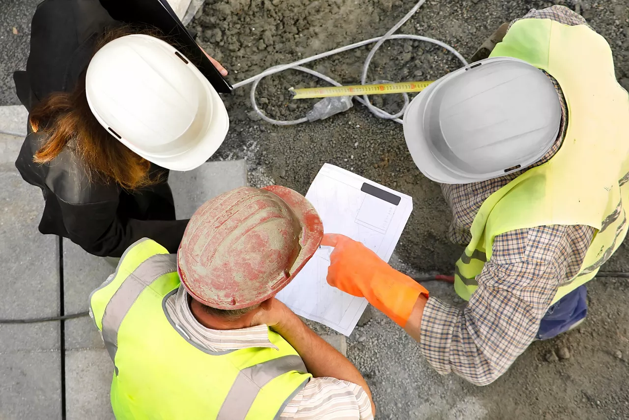 female engineer at construction site talking to workers about the works