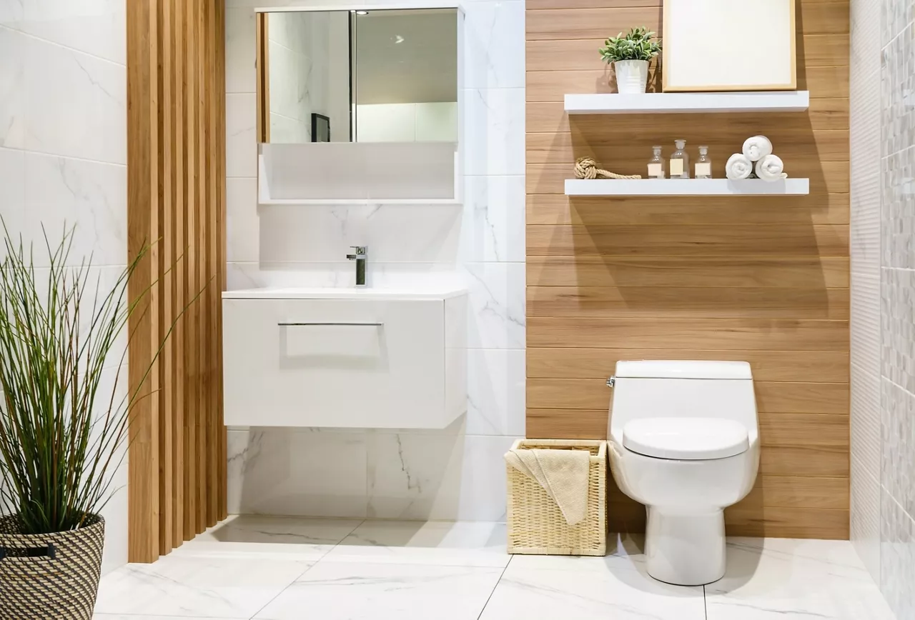 Modern spacious bathroom with bright tiles with toilet and sink. Side view