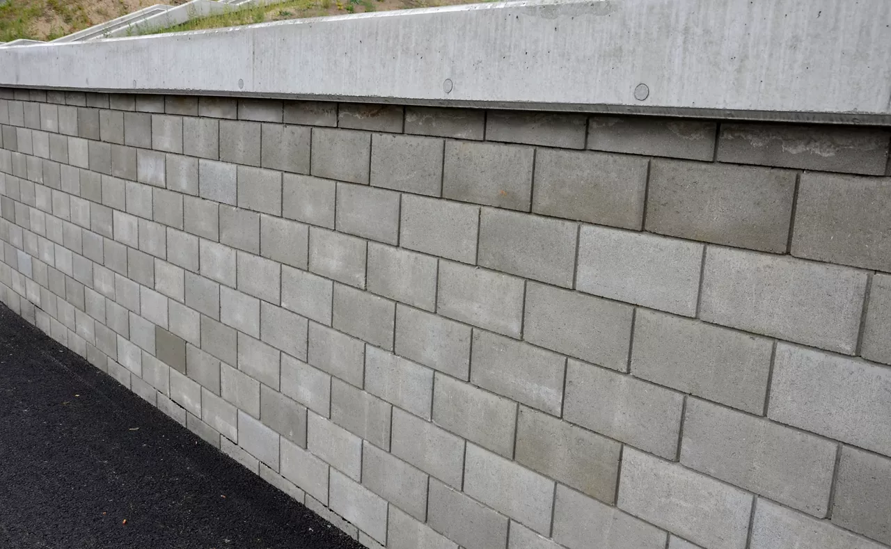 holding a road notch of a bridge forecourt tunnel. retaining wall with concrete grouting is covered with fake, optically prettier wall. fencing with hollow bricks filled with wires, railing,steel