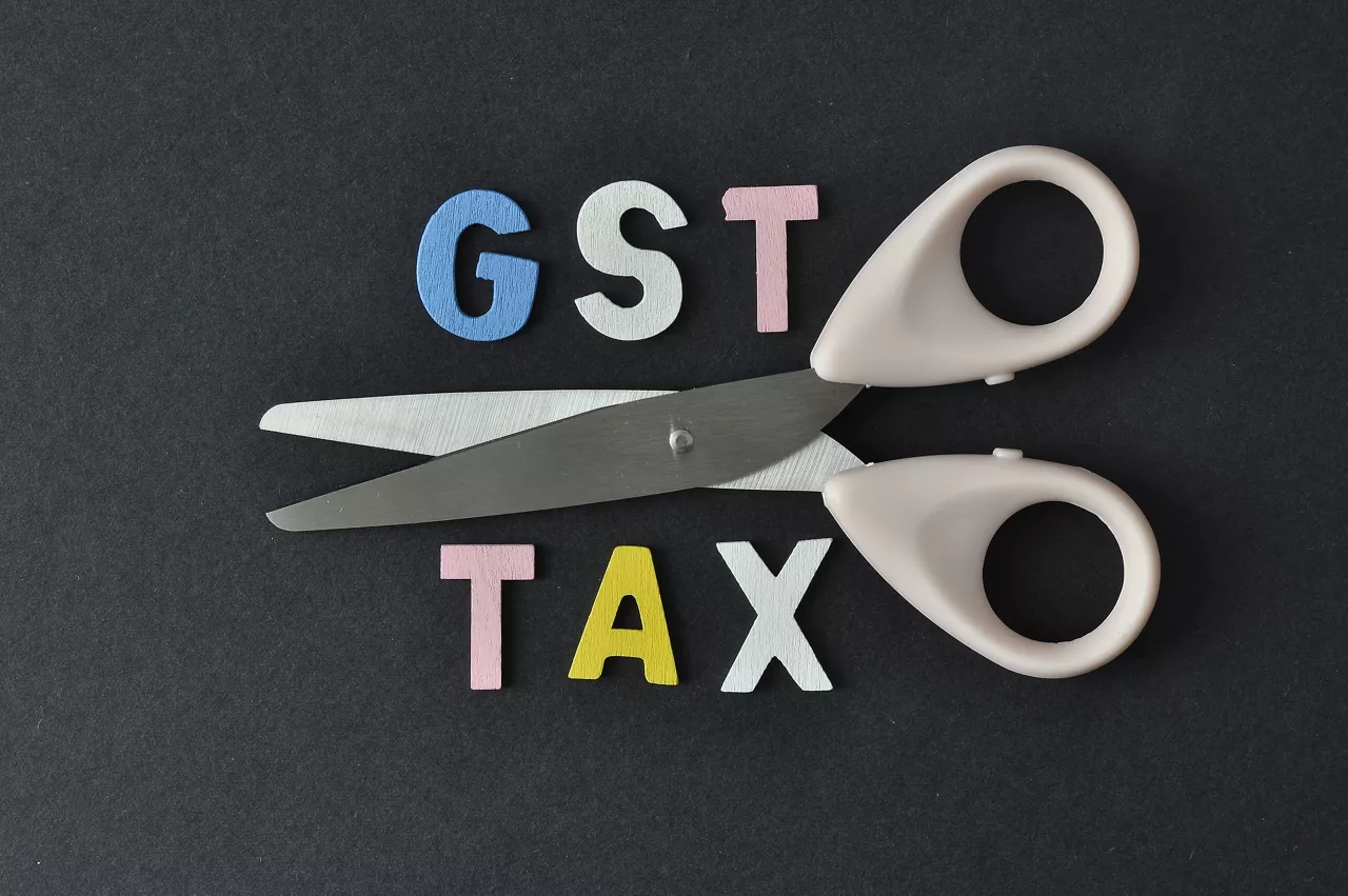 Scissor and word of GST and TAX on black background