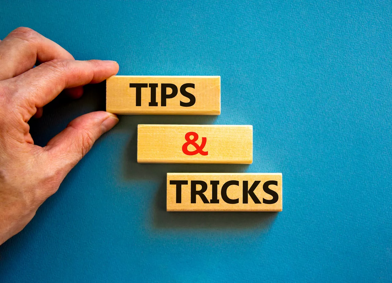 Tips and tricks symbol. Concept words Tips and tricks on wooden blocks. Beautiful blue table blue background. Businessman hand. Business, tips and tricks concept. Copy space.