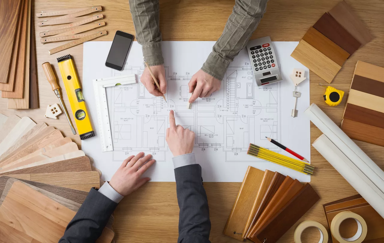 Customer businessman and construction engineer working together on a building project, desktop top view