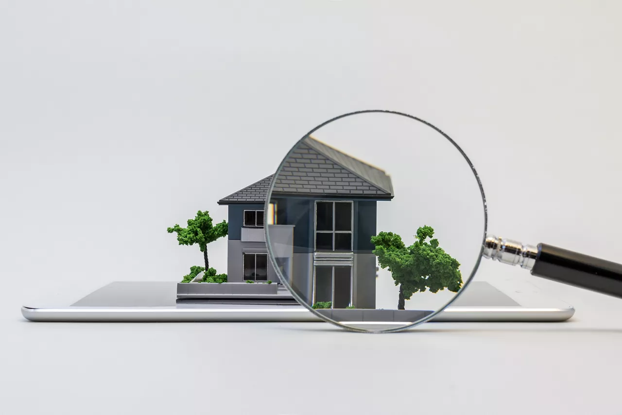 house miniature model on tablet pc and magnifying glass, searching or checking concept