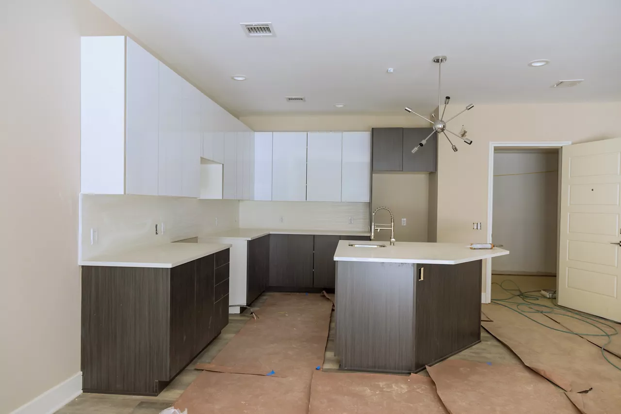Under construction is new home with custom modular kitchen comprised of cabinets an island in center.
