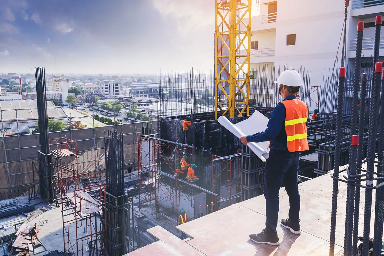 Smart civil architect engineer inspecting and working outdoors building side with blueprints. engineering and architecture concept.