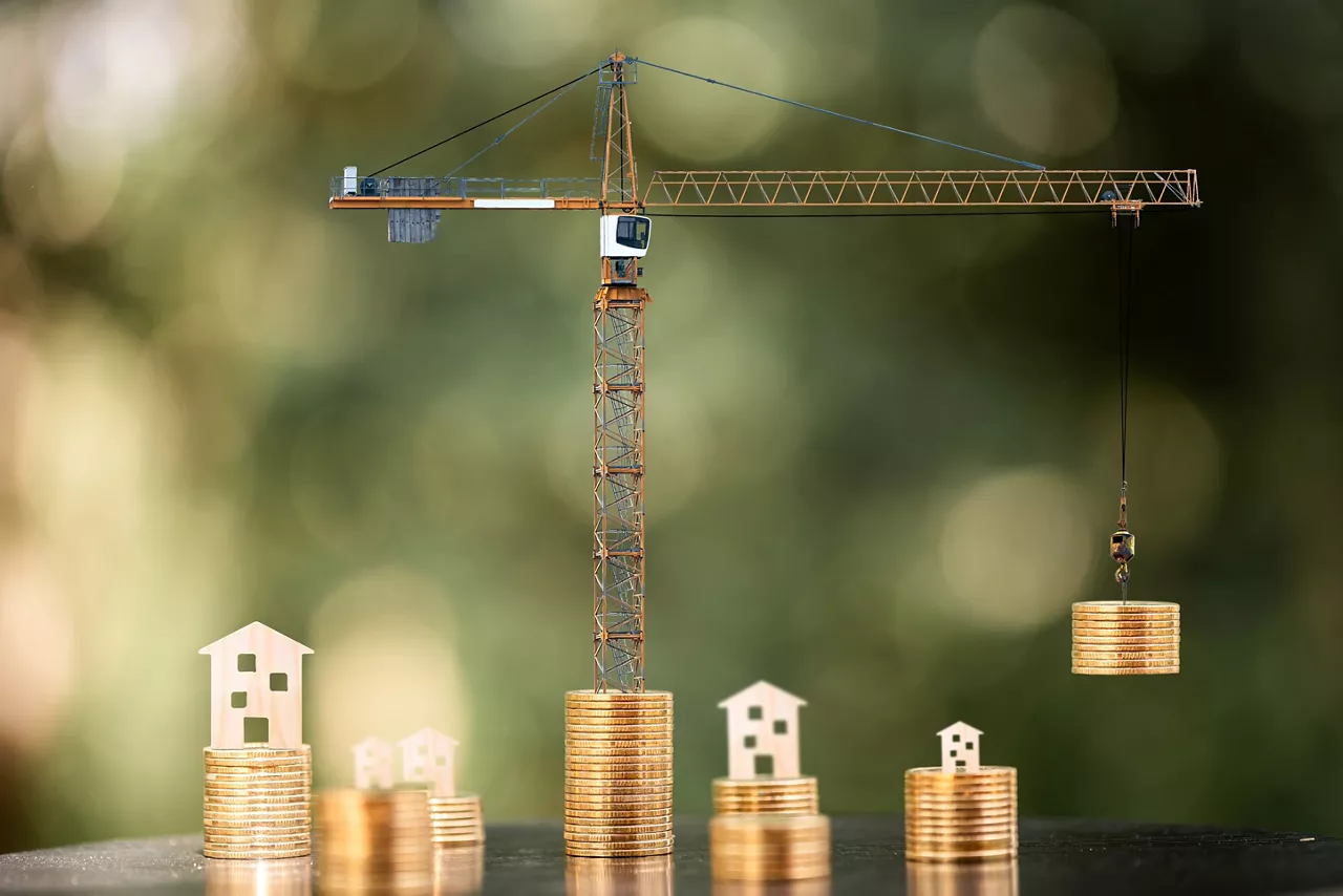 Home put on the stack gold coin and tower crane and hoist brake solution transporting the money with build the house put on the wood, Saving money and loan for construction real estate concept.