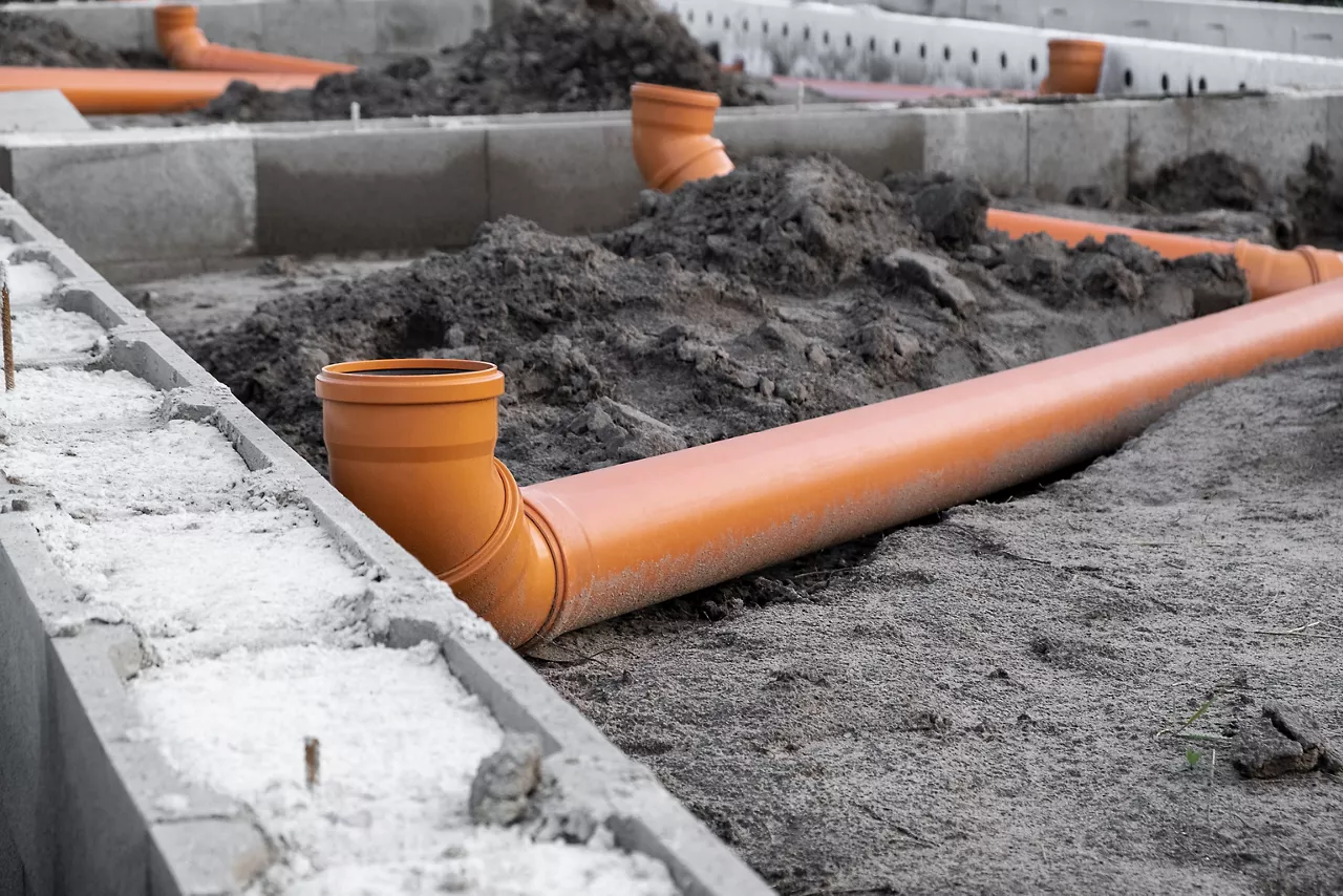 New Installed pipework system. Sewer Line developed and mounted on the construction site. New Orange PVC plastic Drainage pipe Tube