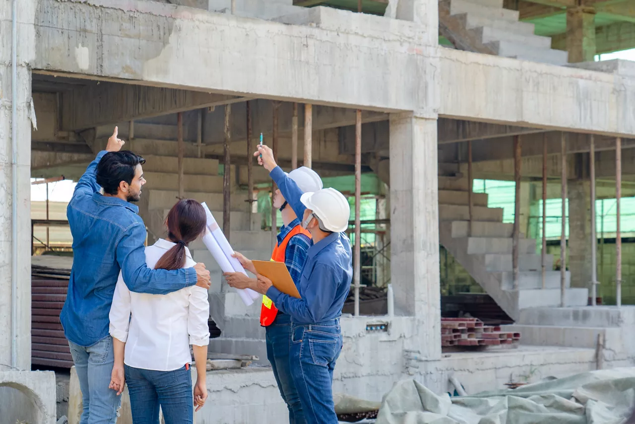 engineer or architect explain house renovation design to young couple owner while inspecting material of infrastructure construction at site, contractor explain progress building and timeline