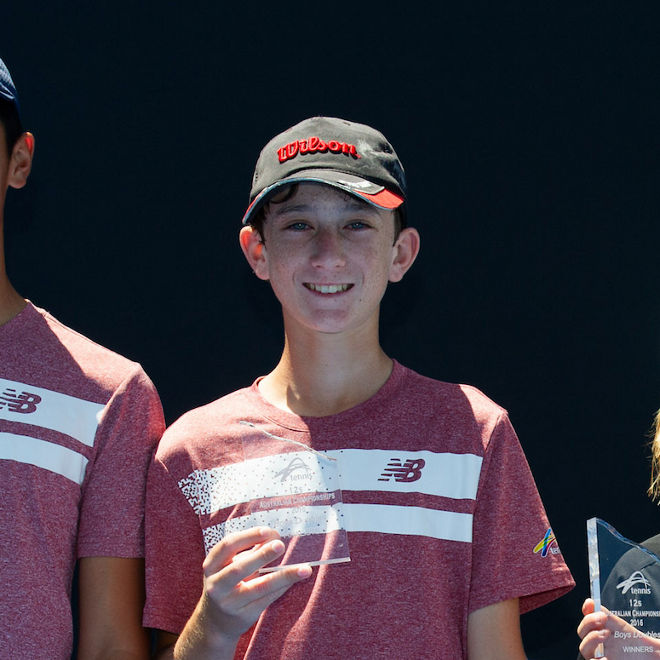 Alex Braund stabds with other young tennis players 