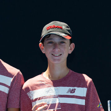 Alex Braund stabds with other young tennis players 
