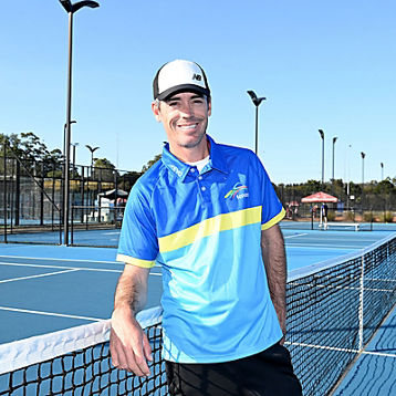 Alun Jones poses at a tennis net