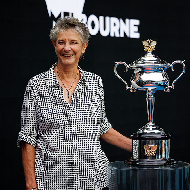 Chris O'neil smiles holding a tennis trophy