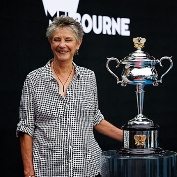 Chris O'neil smiles holding a tennis trophy