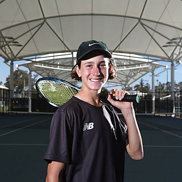 Elijah Dikkenberg poses with a tennis racquet