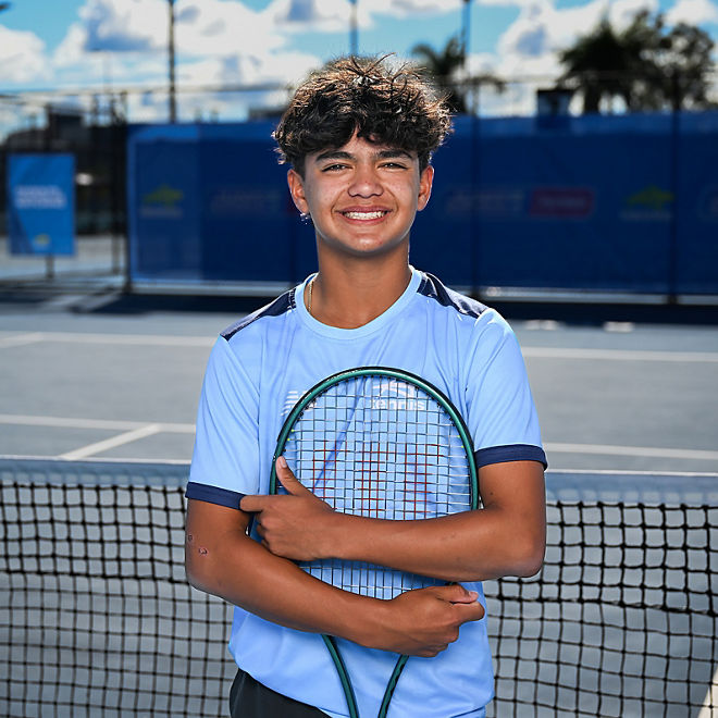 Ethan Domingo poses with his racquet on a tennis court