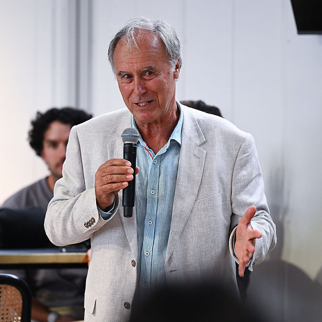 John Alexander holds a microphone talking to the crowd