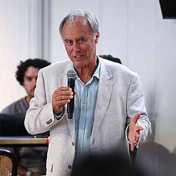 John Alexander holds a microphone talking to the crowd