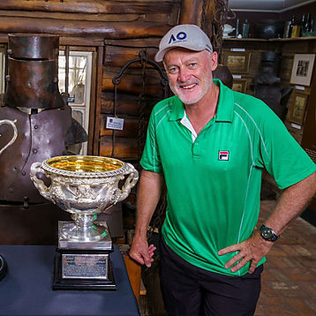 John Fitzgerald poses with tennis trophies