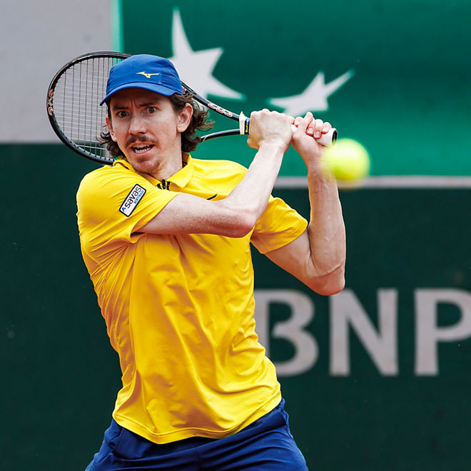 John Patrick Smith hits a tennis shot