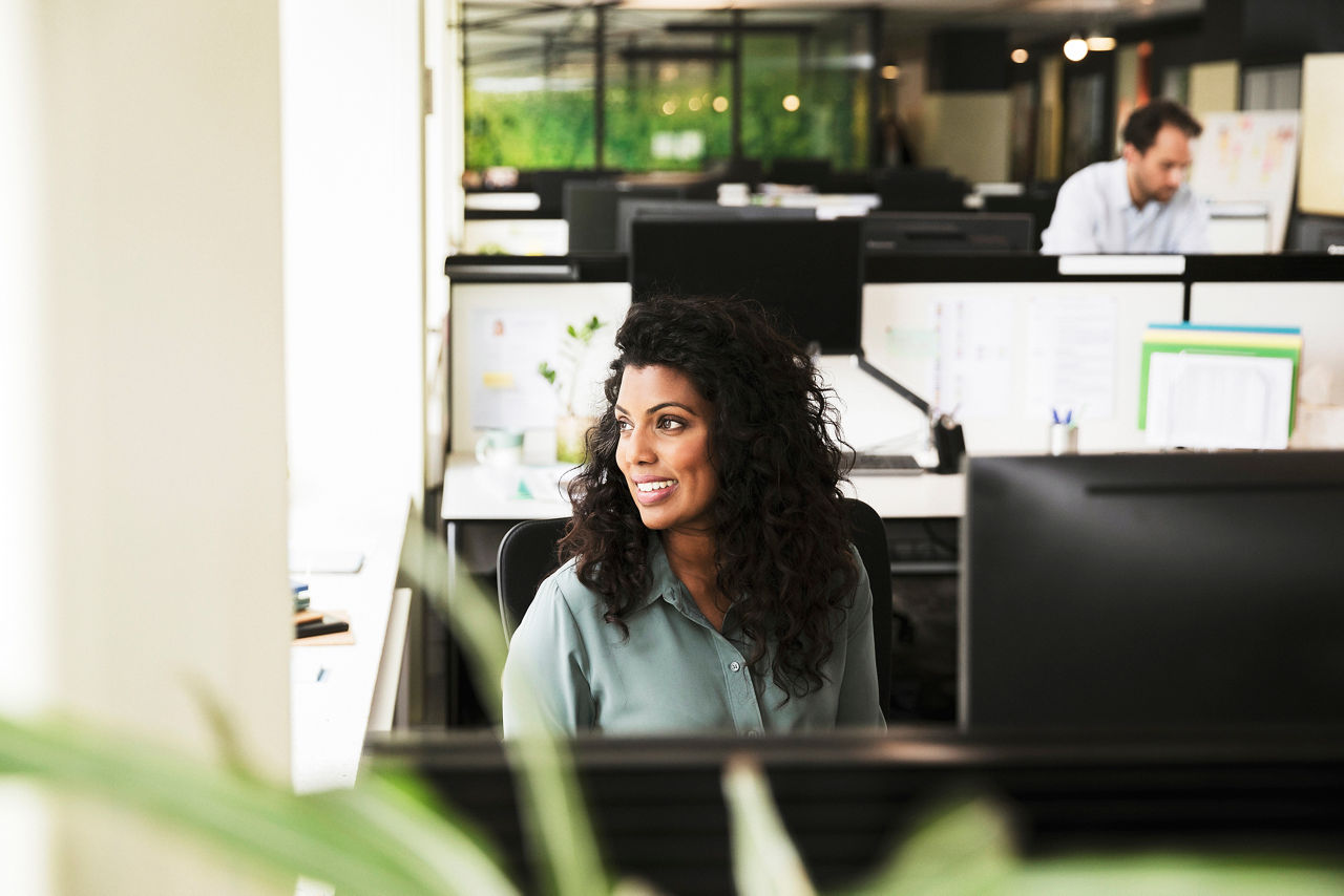 Woman sitting at desk in the office looking out of the window