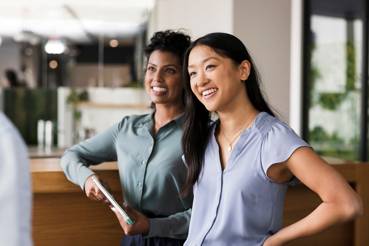 Two women in the office looking at third person