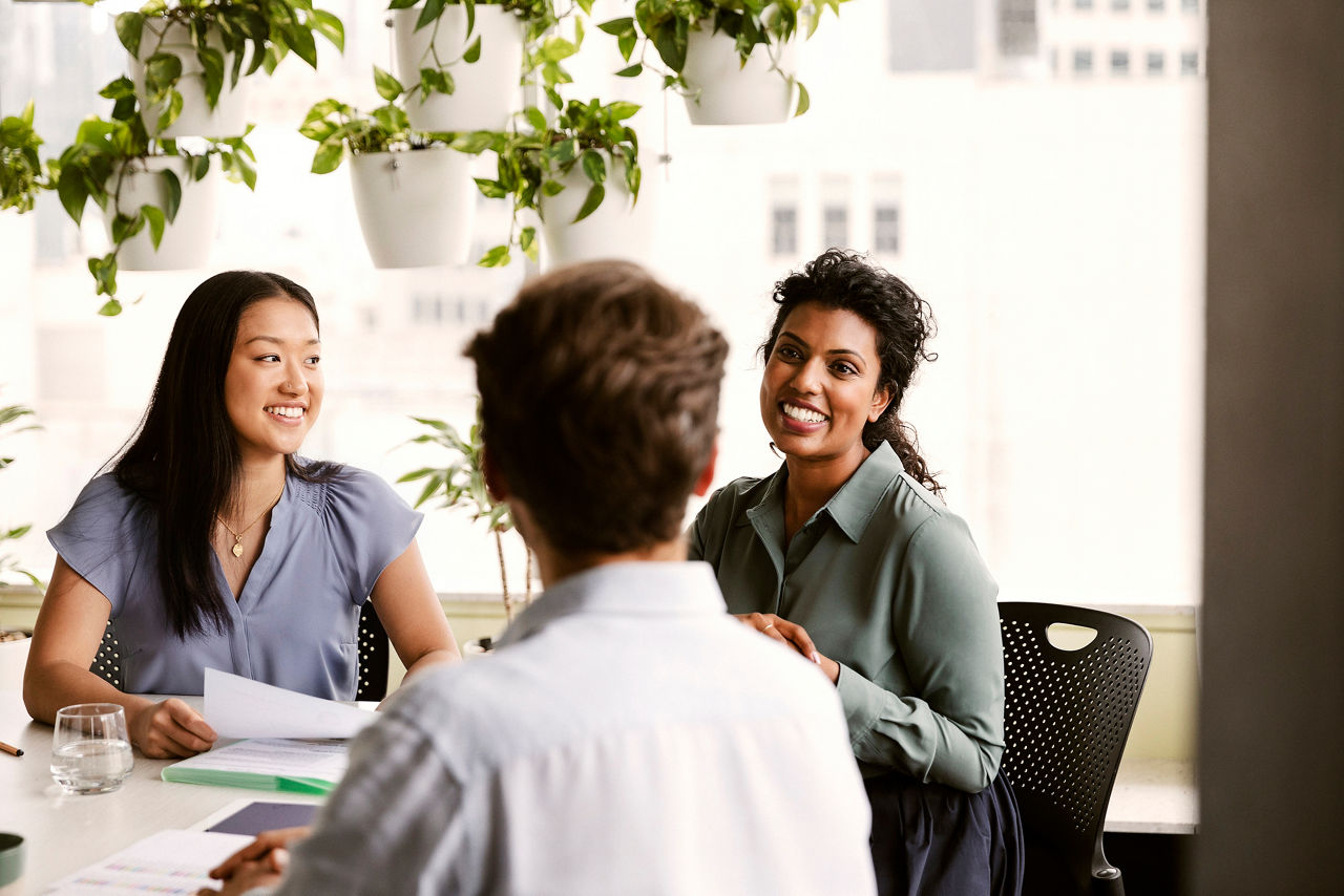 Three colleagues talking at meeting table