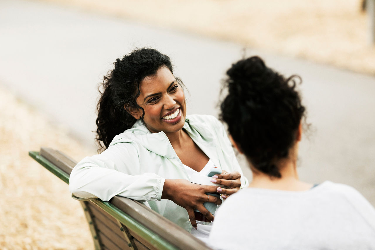 Two women chatting on park bench