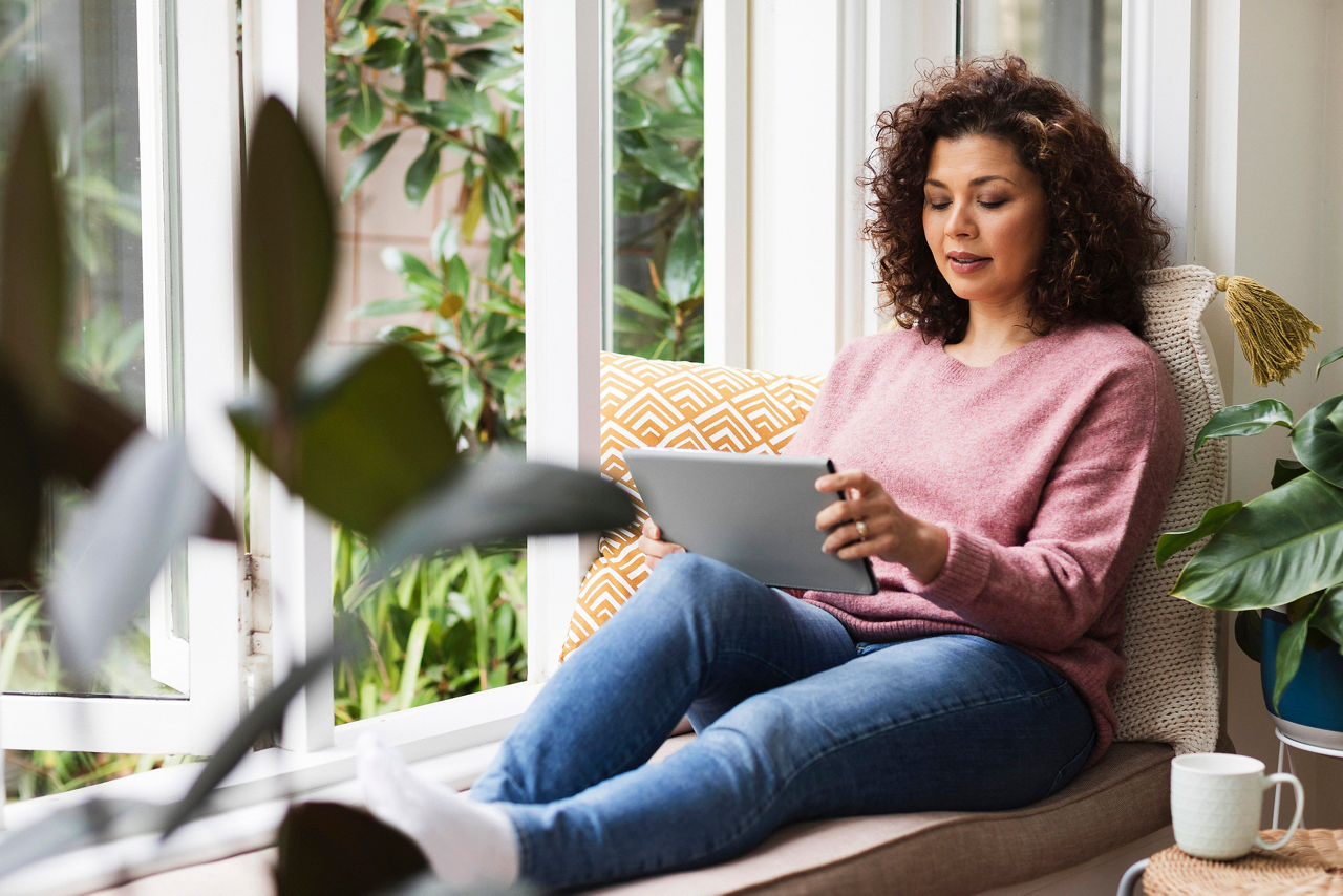 Women sitting near window looking at tablet