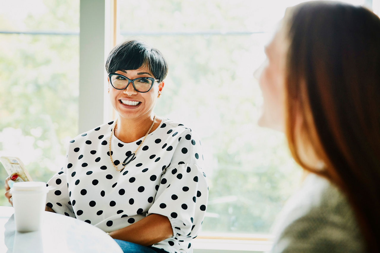 Smiling businesswoman in discussion with colleague in office conference room
