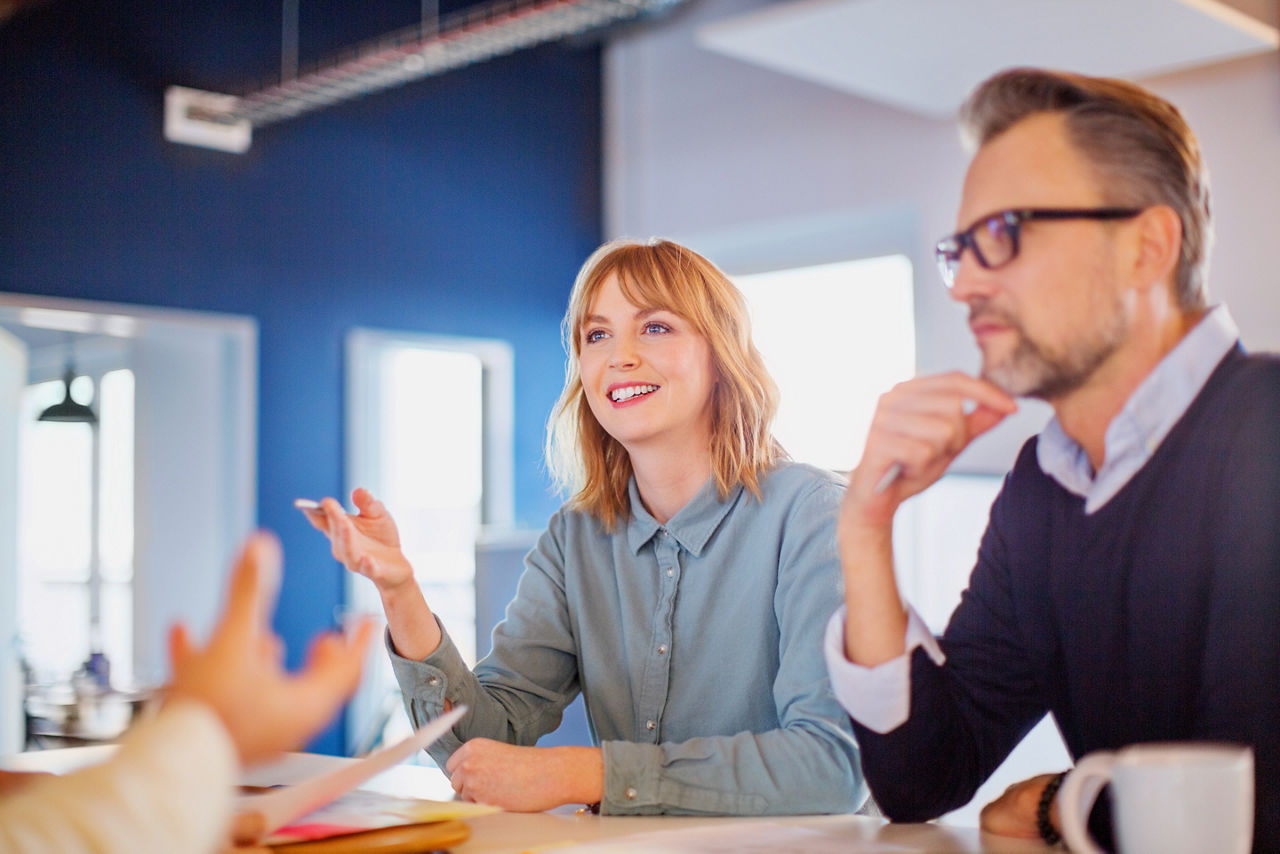 Corporate business woman and manager in a meeting.  Woman in meeting sharing creative ideas and telling her opinion at group briefing.