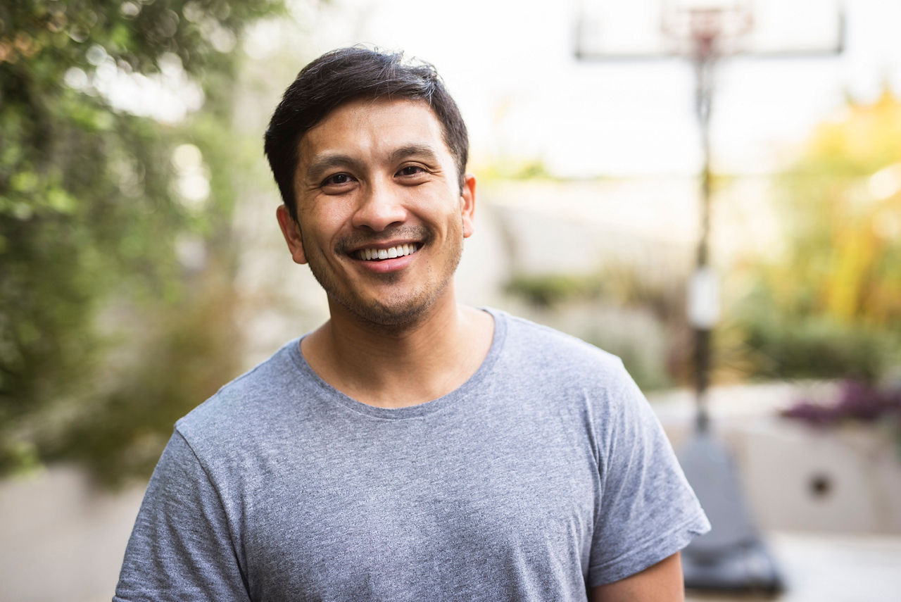 Hispanic adult standing outside and smiling