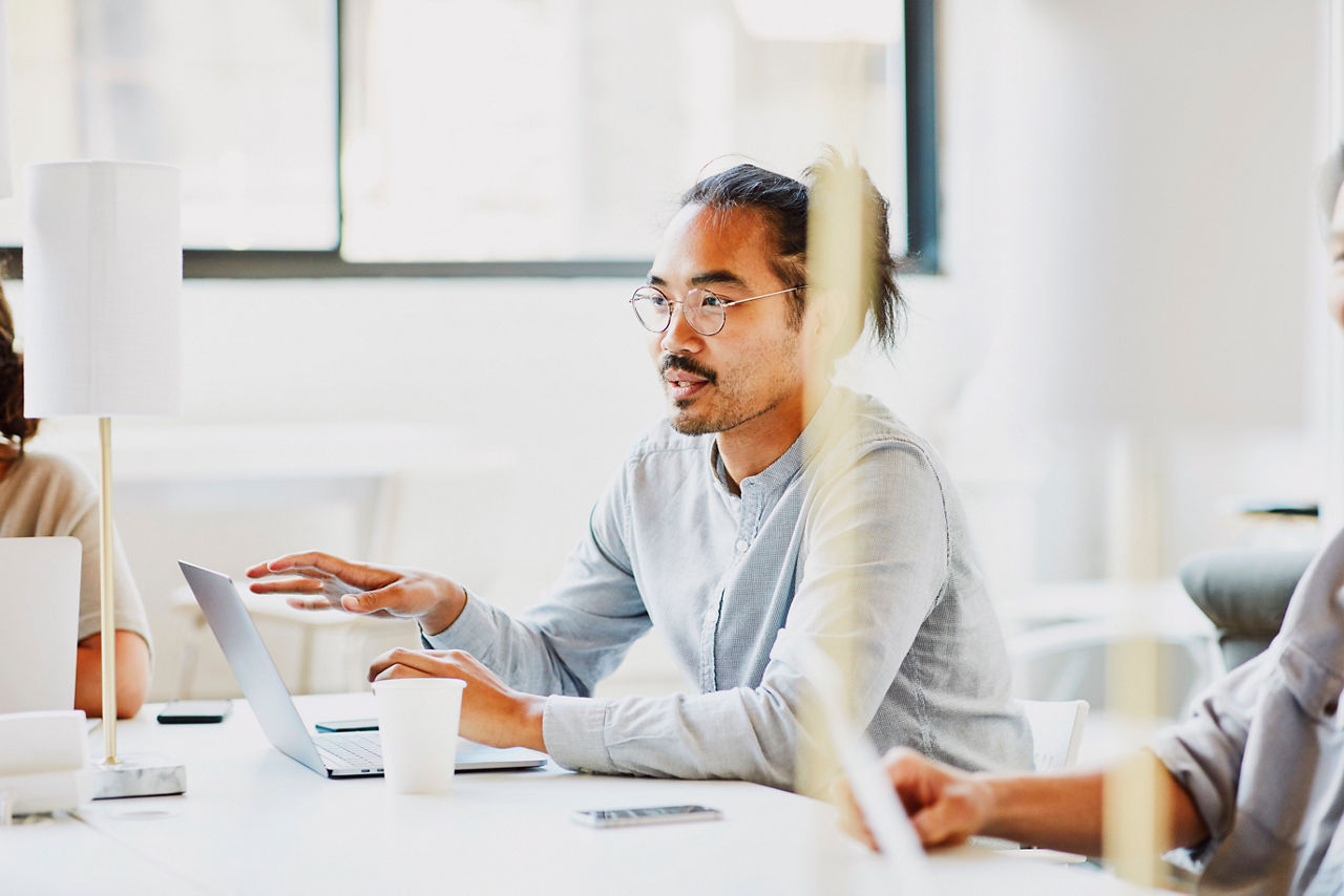 Businessman sharing ideas during team meeting in office conference room