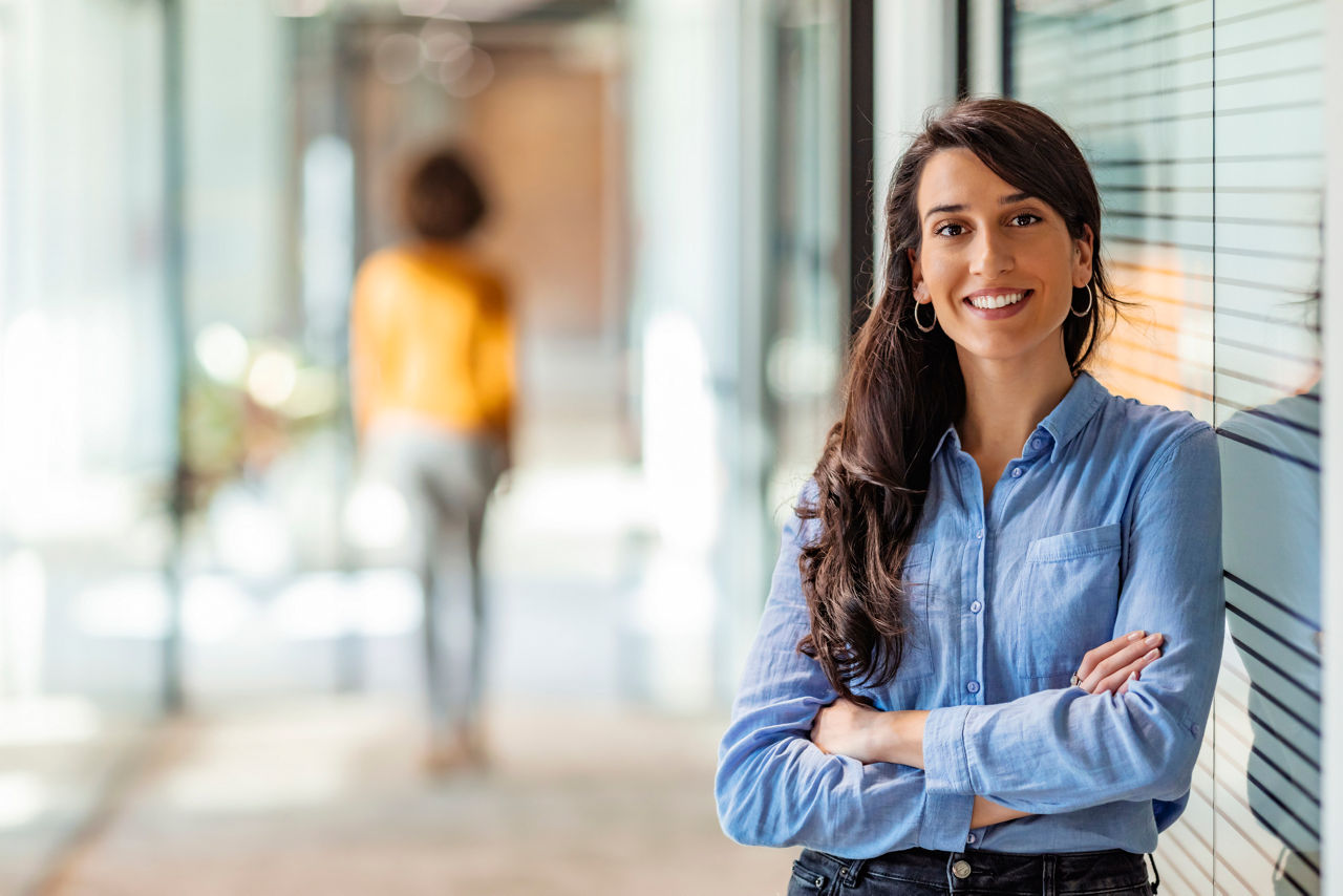 One Happy Pretty Business Woman Standing in Hall and looking at camera with smile.