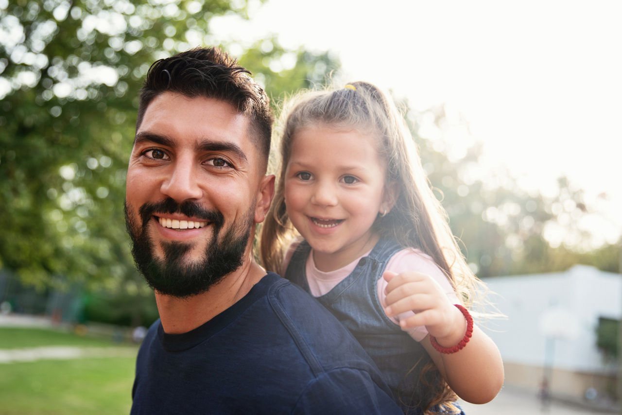 happy father giving his little daughter a piggy back ride