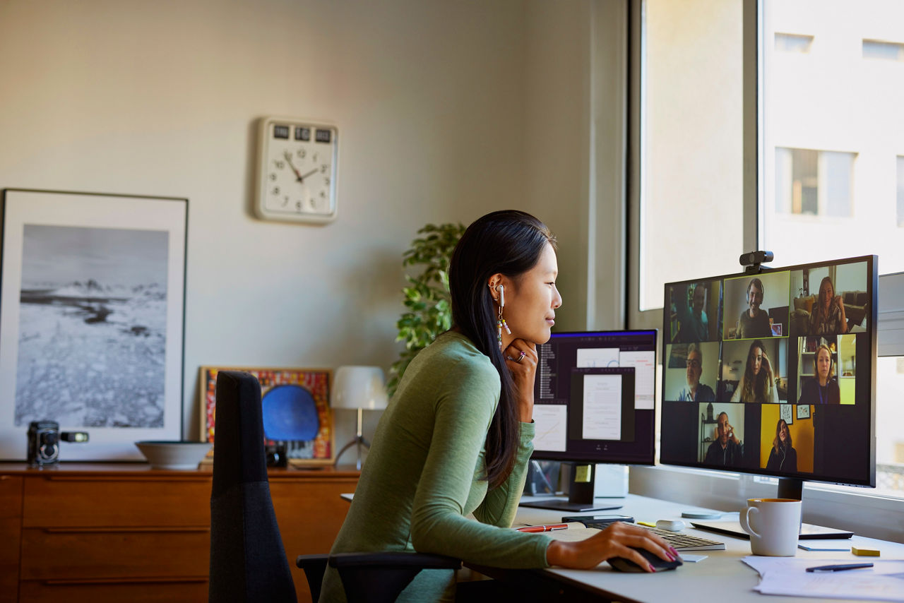 Businesswoman discussing during video conference. Multiracial male and female colleagues are attending online meeting. She is at home office.