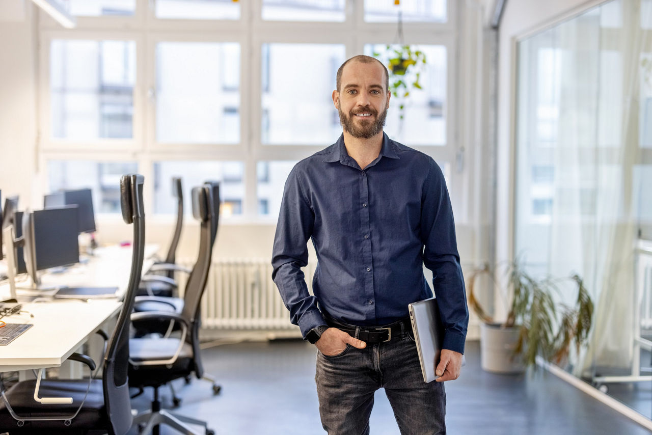 Smiling male professional in casual clothing looking at camera at office. Portrait of a confident mature businessman.