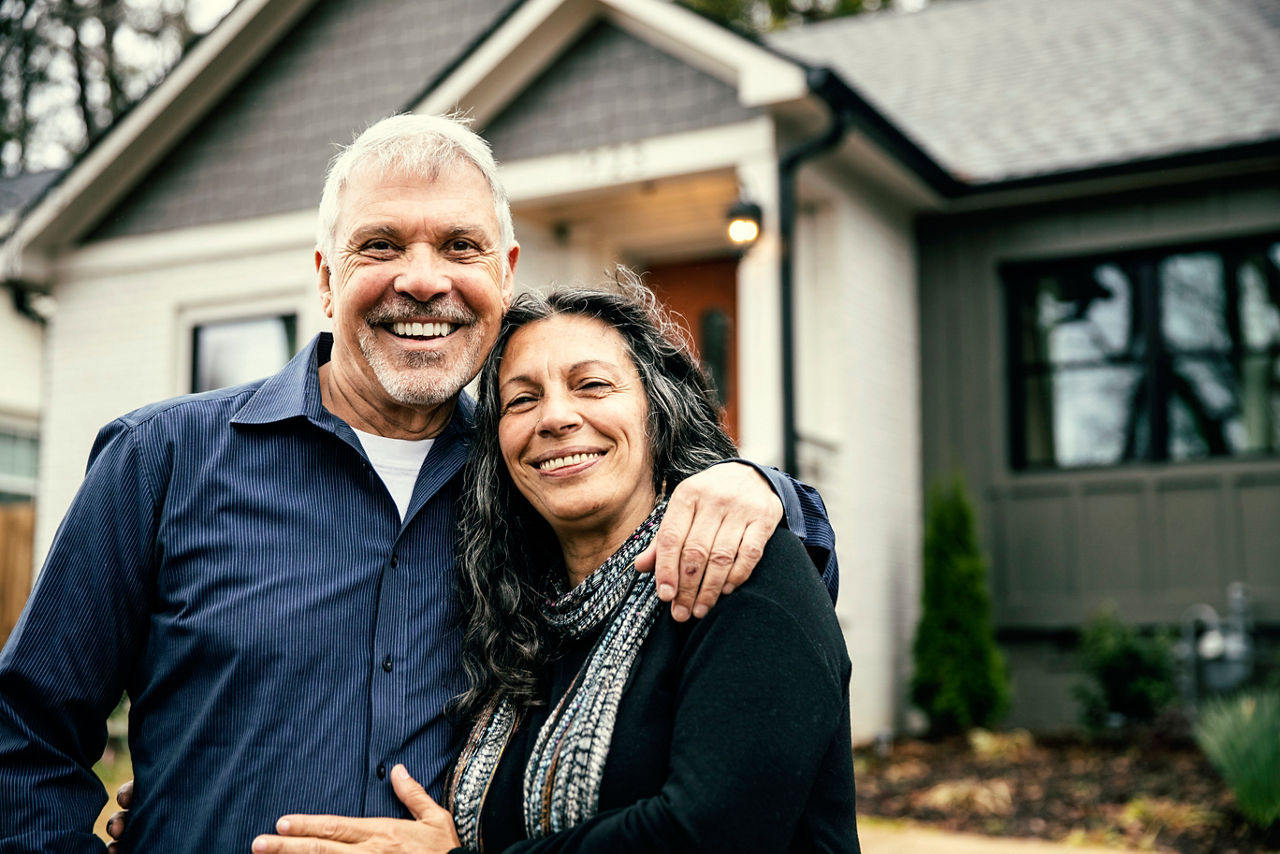 Portrait of senior couple in front of home